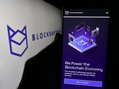 Stuttgart, Almanya - 03-06-2024: Blockdaemon Inc. adlı yazılım şirketinin logo önünde web sayfası bulunan kişi. Telefon ekranının merkezine odaklan.