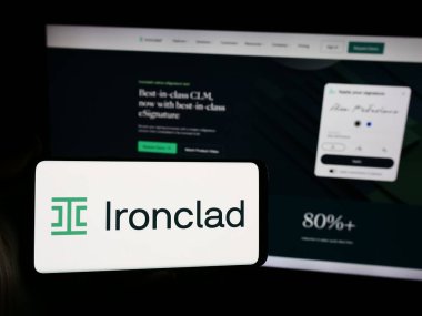 Stuttgart, Almanya - 06-05-2024: İnternet sitesinin önünde ABD 'li sözleşmeli yazılım şirketi Ironclad Inc.' in logosuna sahip akıllı telefon sahibi kişi. Telefon ekranına odaklan.