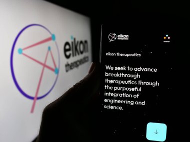 Stuttgart, Almanya - 06-05-2024: ABD 'li biyoteknoloji şirketi Eikon Therapeutics' in web sayfası ile logo önünde cep telefonu tutan kişi. Telefon ekranının merkezine odaklan.