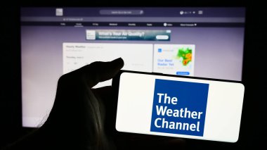 Stuttgart, Almanya - 06-06-2024: İnternet sayfası önünde Amerikan ankesörlü televizyon kanalı logosu olan cep telefonu sahibi kişi. Telefon ekranına odaklan.