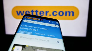Stuttgart, Almanya - 06-06-2024: Alman hava portalı şirketi Wetter.com GmbH 'nin web sitesi ile birlikte iş logosu önünde cep telefonu. Telefon ekranının sol üst kısmına odaklan.