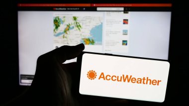 Stuttgart, Almanya - 06-06-2024: İnternet sayfası önünde Amerikan hava durumu tahminleri şirketi Accuather Inc. 'in logosuna sahip cep telefonu sahibi kişi. Telefon ekranına odaklan.