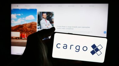 Stuttgart, Almanya - 06-06-2024: Brezilyalı lojistik platformu CargoX 'un logosu olan cep telefonunu işletme web sitesinin önünde tutan kişi. Telefon ekranına odaklan.