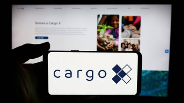 Stuttgart, Almanya - 06-06-2024: Brezilyalı lojistik platformu CargoX 'un logosu olan cep telefonu sahibi kişi iş sayfasının önünde. Telefon ekranına odaklan.