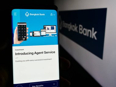 Stuttgart, Almanya - 06-07-2024: İş logosu önünde Thai Bangkok Bank Public Company Limited web sayfası ile akıllı telefon tutan kişi. Telefon ekranının merkezine odaklan.