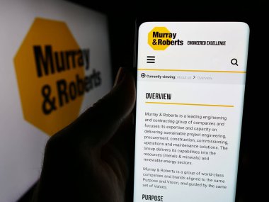 Stuttgart, Almanya - 06-11-2024: Güney Afrikalı Murray ve Roberts Holding Ltd. şirketinin logolu internet sitesi ile cep telefonu tutan kişi. Telefon ekranının merkezine odaklan.