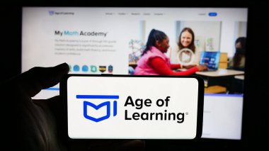 Stuttgart, Almanya - 06-11-2024: ABD 'li online eğitim şirketi Age of Learning Inc.' in logosuyla cep telefonu sahibi olan kişi iş sayfasının önünde. Telefon ekranına odaklan.