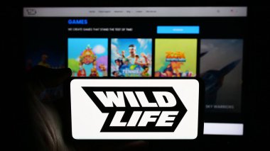 Stuttgart, Almanya - 06-11-2024: Brezilyalı oyun şirketi Wild Life Inc. (Vahşi Yaşam Stüdyoları) 'un logosunun bulunduğu cep telefonu web sayfası önünde. Telefon ekranına odaklan.