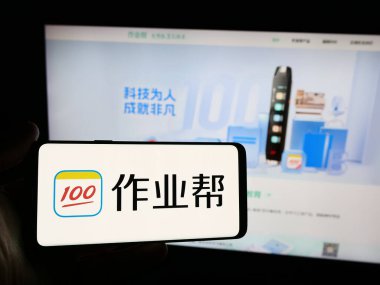 Stuttgart, Almanya - 06-11-2024: İnternet sitesi önünde Çinli online eğitim platformu şirketi Zuoyebang 'ın logosuna sahip kişi. Telefon ekranına odaklan.