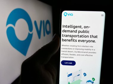 Stuttgart, Almanya - 06-12-2024: ABD 'li hareketlilik şirketi Via Transportation Inc. (RideWithVia)' nin logolu web sitesi ile akıllı telefon sahibi olan kişi. Telefon ekranının merkezine odaklan.