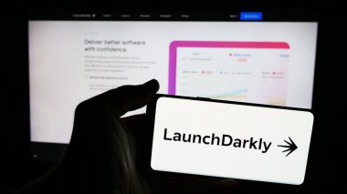 Stuttgart, Almanya - 06-12-2024: İnternet sayfası önünde Amerikan yazılım şirketi Catamorphic Co. (LaunchDarkly) logosu olan cep telefonu sahibi kişi. Telefon ekranına odaklan.