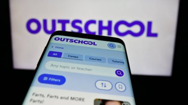 Stuttgart, Almanya - 06-12-2024: İş logosu önünde ABD 'li çevrimiçi eğitim şirketi Outschool Inc.' nin web sitesiyle cep telefonu. Telefon ekranının sol üst kısmına odaklan.