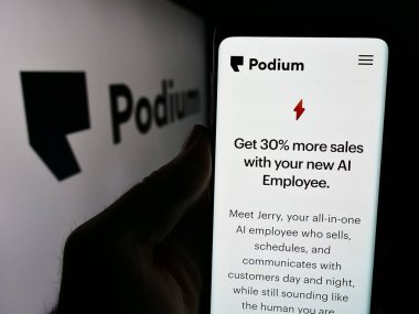 Stuttgart, Almanya - 06-12-2024: ABD 'li yazılım şirketi Podium Corporation Inc.' in web sayfası ile logo önünde cep telefonu tutan kişi. Telefon ekranının merkezine odaklan.