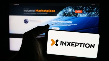 Stuttgart, Almanya - 06-13-2024: İnternet sayfası önünde üzerinde Amerikan e-ticaret platformu şirketi Inxeption Corporation 'ın logosu olan cep telefonu tutan kişi. Telefon ekranına odaklan.