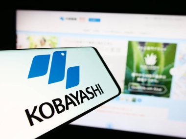 Stuttgart, Germany - 06-24-2024: Cellphone with logo of Japanese company Kobayashi Pharmaceutical Co. Ltd. in front of business website. Focus on center-right of phone display. clipart