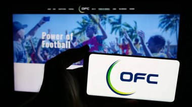 Stuttgart, Almanya - 06-25-2024: İnternet sitesi önünde Okyanusya Futbol Konfederasyonu (OFC) logosu olan akıllı telefon sahibi kişi. Telefon ekranına odaklan.