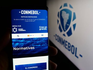 Stuttgart, Almanya - 06-25-2024: Logo önünde Konfederasyon Sudamericana de Futbol (CONMEBOL) web sayfası bulunan kişi. Telefon ekranının merkezine odaklan.