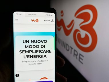 Stuttgart, Almanya - 06-26-2024: Telekomünikasyon şirketi Wind Tre S.p.A. 'nın (WINDTRE) internet sayfası ile cep telefonu tutan kişi. Telefon ekranının merkezine odaklan.