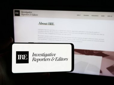 Stuttgart, Almanya - 06-26-2024: İnternet sitesi önünde üzerinde Araştırmacı Gazeteciler ve Editörler Inc. (IRE) logosu bulunan kişi. Telefon ekranına odaklan.