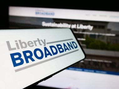 Stuttgart, Almanya - 06-26-2024: Amerikan Liberty Broadband Corporation (LBRDA) şirketinin logosuna sahip cep telefonu. Telefon ekranının soluna odaklan.