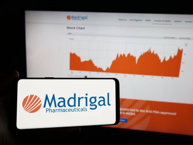 Stuttgart, Almanya - 06-26-2024: Biyofarmasötik şirketi Madrigal Pharmaceuticals Inc. 'in logosunun bulunduğu cep telefonu web sayfasının önünde duruyor. Telefon ekranına odaklan.