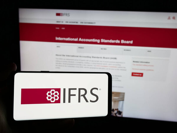 Stuttgart, Germany - 06-26-2024: Person holding smartphone with logo of International Financial Reporting Standards Foundation (IFRS) in front of website. Focus on phone display.