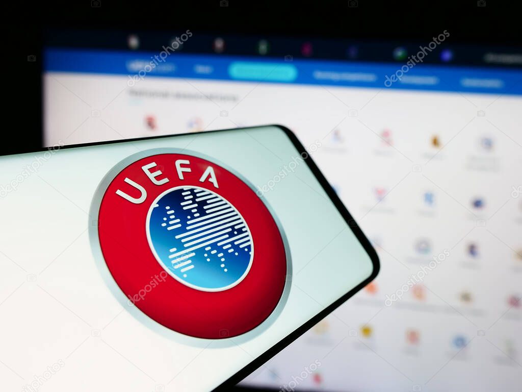 Stuttgart, Germany - 06-25-2024: Smartphone with logo of Union of European Football Associations (UEFA) in front of website. Focus on center-left of phone display.
