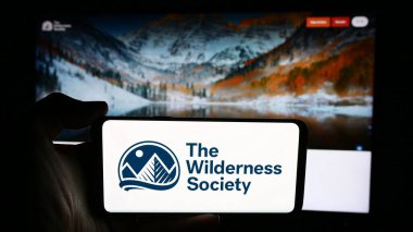 Stuttgart, Almanya - 06-27-2024: Web sayfası önündeki The Wilderness Society adlı Amerikan arazi koruma örgütünün logosuna sahip kişi. Telefon ekranına odaklan.