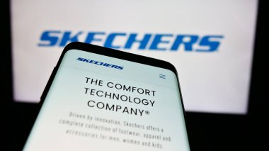 Stuttgart, Almanya - 06-27-2024: İş logosu önünde ABD 'li ayakkabı şirketi Skechers USA Inc.' in web sitesi ile cep telefonu. Telefon ekranının sol üst kısmına odaklan.