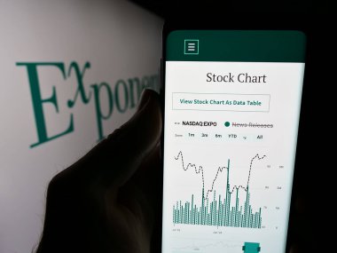 Stuttgart, Almanya - 06-27-2024: ABD 'li bilimsel danışmanlık şirketi Exponent Inc.' in web sitesi ile logo önünde cep telefonu tutan kişi. Telefon ekranının merkezine odaklan.
