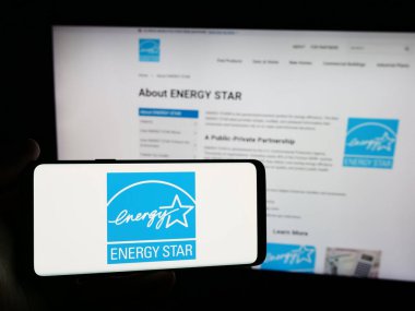 Stuttgart, Almanya - 07-01-2024: İnternet sitesinin önünde ABD enerji verimlilik programı Enerji Yıldızı logosu taşıyan kişi. Telefon ekranına odaklan.