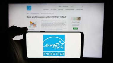 Stuttgart, Almanya - 07-01-2024: İnternet sayfasının önünde ABD enerji verimlilik programı Enerji Yıldızı logosu bulunan kişi. Telefon ekranına odaklan.