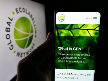 Stuttgart, Almanya - 07-01-2024: Logo önünde Küresel Eko Etiketleme Ağı (GEN) örgütünün web sitesi ile cep telefonu tutan kişi. Telefon ekranının merkezine odaklan.
