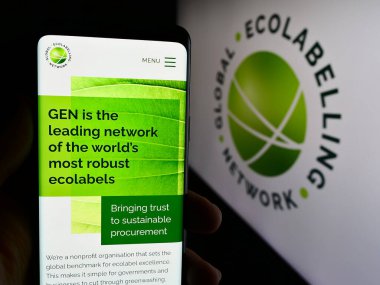 Stuttgart, Almanya - 07-01-2024: Logo önünde Küresel Eko Etiketleme Ağı (GEN) örgütünün web sayfası ile cep telefonu tutan kişi. Telefon ekranının merkezine odaklan.