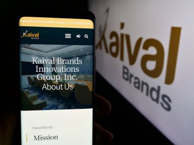 Stuttgart, Almanya - 07-01-2024: ABD 'li şirket Kaival Brands Innovations Group Inc.' in web sayfası ile logo önünde cep telefonu tutan kişi. Telefon ekranının merkezine odaklan.