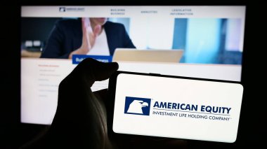 Stuttgart, Almanya - 07-01-2024: American Equity Investment Life Holding Company 'nin logosuna sahip cep telefonu sahibi kişi iş sayfasının önünde. Telefon ekranına odaklan.