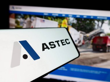 Stuttgart, Germany - 07-03-2024: Smartphone with logo of American equipment company Astec Industries Inc. in front of business website. Focus on center-left of phone display. clipart