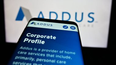 Stuttgart, Almanya - 07-03-2024: ABD 'li ev bakımı şirketi Addus HomeCare Corporation' ın web sitesi ile ticaret logosu önünde akıllı telefon. Telefon ekranının sol üst kısmına odaklan.