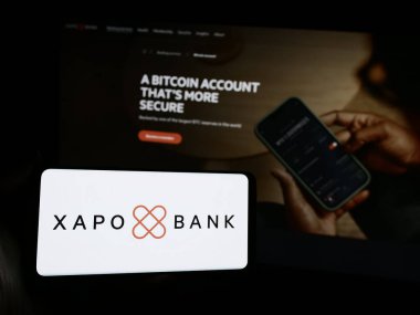 Stuttgart, Almanya - 07-03-2024: Şifreli bankacılık şirketi Xapo Holding Limited 'in logosuna sahip akıllı telefon sahibi kişi web sitesi önünde. Telefon ekranına odaklan.