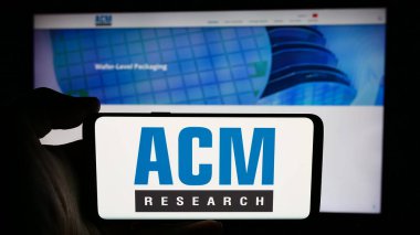 Stuttgart, Almanya - 07-03-2024: ABD 'li yarı iletken şirket ACM Research Inc.' in logosuyla cep telefonu sahibi kişi iş sayfasının önünde. Telefon ekranına odaklan.