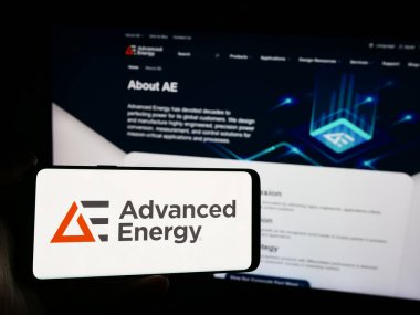 Stuttgart, Almanya - 07-03-2024: İnternet sitesi önünde üzerinde ABD 'li teknoloji şirketi Advanced Energy Industries Inc.' in logosu bulunan kişi. Telefon ekranına odaklan.