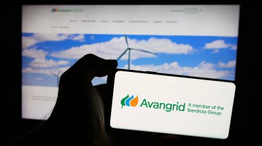 Stuttgart, Almanya - 07-03-2024: İnternet sitesi önünde ABD 'li enerji hizmetleri şirketi Avangrid Inc.' in logosuna sahip kişi. Telefon ekranına odaklan.