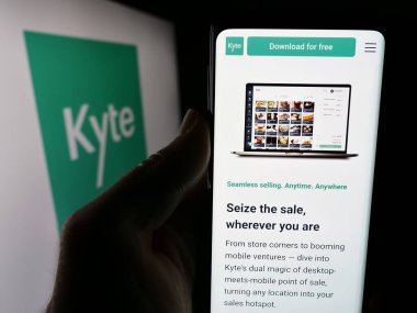 Stuttgart, Almanya - 07-04-2024: Brezilyalı POS şirketi Kyte Tecnologia de Software Ltda 'nın internet sayfası ile cep telefonu tutan kişi. Logolu. Telefon ekranının merkezine odaklan.