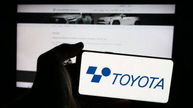 Stuttgart, Almanya - 07-05-2024: Japon makine şirketi Toyota Industries Corporation 'ın logosunun bulunduğu cep telefonu sahibi kişi web sayfasının önünde. Telefon ekranına odaklan.