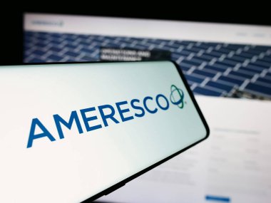 Stuttgart, Germany - 07-05-2024: Mobile phone with logo of American renewable energy company Ameresco Inc. in front of business website. Focus on center-left of phone display. clipart