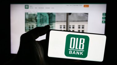 Stuttgart, Almanya - 07-05-2024: İnternet sitesi önünde Alman Oldenburgische Landesbank AG (OLB) logosuna sahip kişi. Telefon ekranına odaklan.