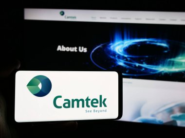 Stuttgart, Almanya - 07-05-2024: İsrailli metroloji ekipman şirketi Camtek Ltd. 'nin logosuna sahip akıllı telefon sahibi kişi web sitesinin önünde. Telefon ekranına odaklan.