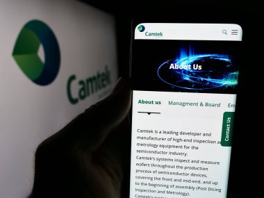 Stuttgart, Almanya - 07-05-2024: İsrailli metroloji ekipman şirketi Camtek Ltd. 'nin web sayfası ile akıllı telefon taşıyan kişi logonun önünde. Telefon ekranının merkezine odaklan.