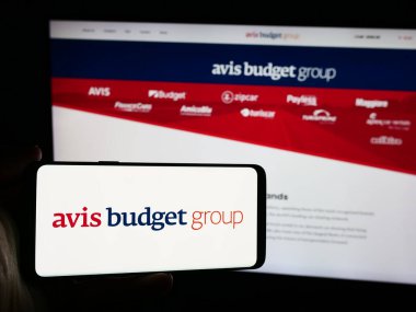 Stuttgart, Almanya - 07-05-2024: Web sitesi önünde ABD 'li kiralık araba şirketi Avis Budget Group Inc.' in logosuna sahip kişi. Telefon ekranına odaklan.