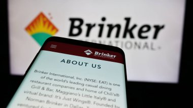 Stuttgart, Germany - 07-05-2024: Smartphone with website of US hospitality company Brinker International Inc. in front of business logo. Focus on top-left of phone display. clipart